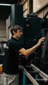 A focused worker operating heavy machinery in an industrial setting.